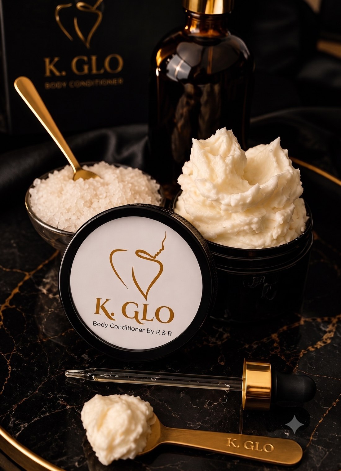 K.GLO whipped body conditioner jars with a gold spoon, dropper, and bath salts on black marble